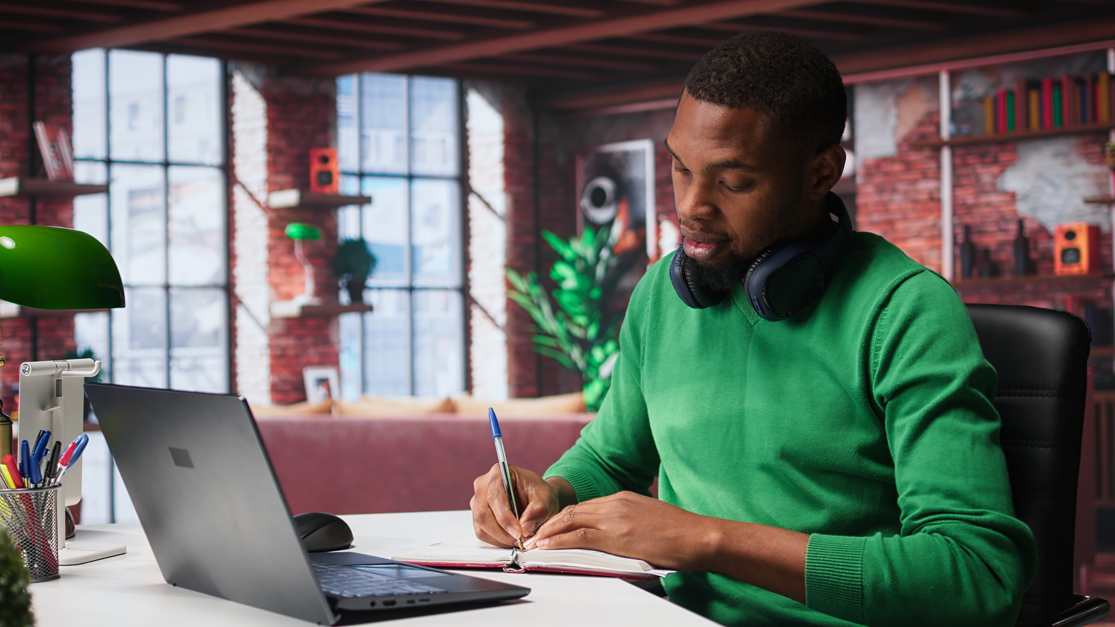 Homem a estudar com laptop e caderno de notas